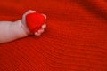 A child holds a red heart in his hand. Newborn baby on Valentine`s Day. Happy Mother`s Day Royalty Free Stock Photo