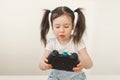 A child holds a remote control from a computer game. Child`s addiction to online games. A keen kid drives a joystick.