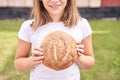 Child holds round bread. Healthy food. Carrying big fresh baker bun