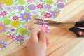 Child holds scissors and paper flower in his hands. Child cuts flowers fragments out paper napkin for decoupage Royalty Free Stock Photo