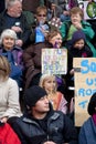 Child holds a sign saying