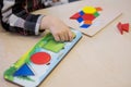 Child holds yellow cardboard circle in hands and puts on corresponding card. Kid learns colors