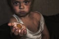 Child homeless, beggar holds a coin in his palm. A gesture of begging concept of war, poverty, crisis