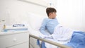 Child in hospital he wakes up and yawns before raising his head to the pillow lying alone in bed