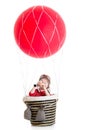Child on hot air balloon watching through spyglass