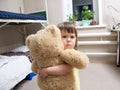 Child hugging teddy bear toy indoor in her room Royalty Free Stock Photo