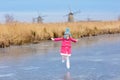 Child ice skating on frozen mill canal in Holland Royalty Free Stock Photo