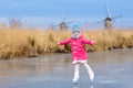 Child ice skating on frozen mill canal in Holland Royalty Free Stock Photo