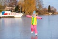 Child ice skating on frozen mill canal in Holland.