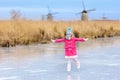 Child ice skating on frozen mill canal in Holland. Royalty Free Stock Photo