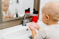 Child independently washes his hands in a bright bathroom with a special disinfectant. Prevention of infectious diseases,