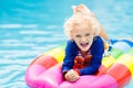 Child on inflatable float in swimming pool.