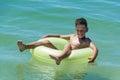 Child with inflatable ring in sea