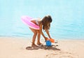 Child with inflatable rubber circle having fun on the beach