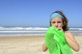 Child inflating inflatable swim ring on the beach