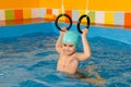 Child in swimming pool excersizing with sport rings Royalty Free Stock Photo