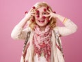 Child isolated on pink background with raspberries on fingers