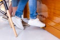 Child in jeans and sneakers press the piano pedal.