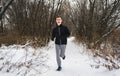 child jogging on a snowy forest in winter Royalty Free Stock Photo