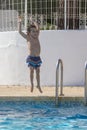 Child Joyfully Jumping into Pool Water