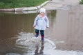 Child jumping in the muddy puddle Royalty Free Stock Photo