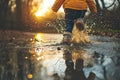 child jumping in a puddle and splashing water everywhere