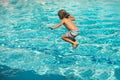 Child jumping in swimming pool. Kid having fun on summer vacation. Royalty Free Stock Photo