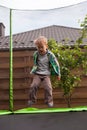 Child jumping on trampoline in the backyard