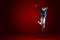 Child jumps, concept of joy, victory on red background copy space