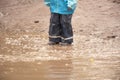 Child jumps in the dirty puddle