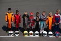 Child kart racers line up next to their helmets at the competition