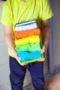 The child keeps his things. The boy puts the T-shirts in a drawer.