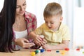 Child kid boy and mother play colorful clay toy at nursery or kindergarten Royalty Free Stock Photo