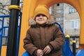 child kid boy playing on a slide on playground in winter in the park Royalty Free Stock Photo