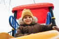 child kid boy playing on a slide on playground in winter in the park Royalty Free Stock Photo