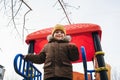 child kid boy playing on a slide on playground in winter in the park Royalty Free Stock Photo