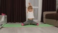 Child kid girl doing gymnastics fitness stretching workout at home, video tutorial distance training Royalty Free Stock Photo