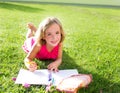 Child kid girl doing homework smiling happy on grass Royalty Free Stock Photo