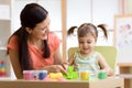 Child kid girl and mother play colorful clay toy at nursery or kindergarten Royalty Free Stock Photo