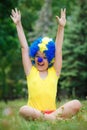 Child kid girl with party clown blue wig funny happy open arms expression and garlands Royalty Free Stock Photo