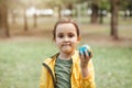 Child kid girl in a yellow raincoat holding globe in a hands outdoor in park or forest. World Earth Day concept. Green Energy, Royalty Free Stock Photo
