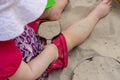 Child with shovel playing in the sandpit