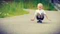 Child kid sitting on skateboard having fun outdoor