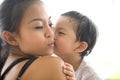 Child kisses his mom on her cheek