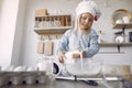 Little girl in a white shef hat cook the dough for cookies Royalty Free Stock Photo