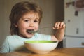 The child in the kitchen at the table eating. Kid eating. Happy child have a breakfast. Food and Drink for Child