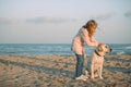 child and labrador dog on beach