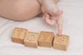 The child laid out the word toys made of wooden cubes, close-up. A small child learns the English alphabet, learns to Royalty Free Stock Photo