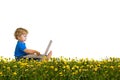 Child with laptop on a dandelion meadow Royalty Free Stock Photo