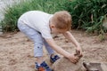 A child and a large stone. Summer holidays. A little boy is playing with stones on the beach. Royalty Free Stock Photo